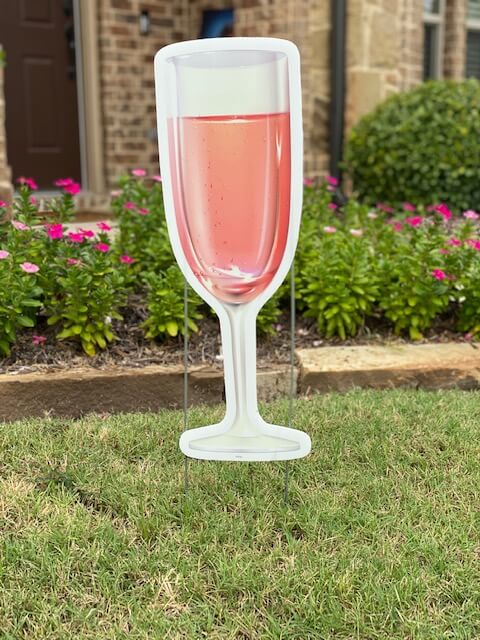 A tall champagne flute with pink champagne