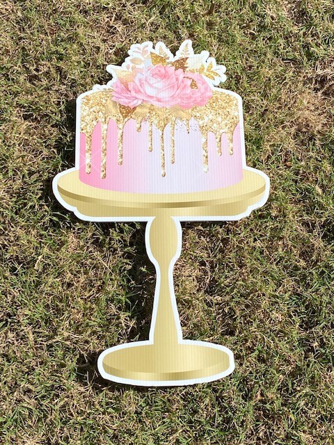 A pink cake on a gold pedestal
