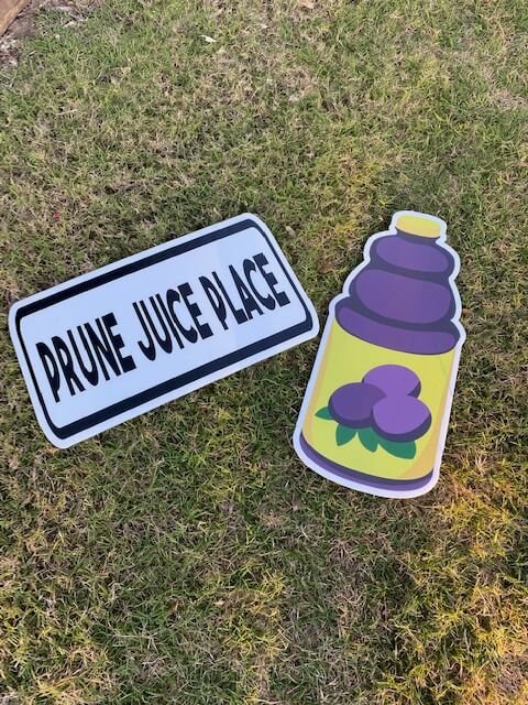 A bottle of prune juice and a sign reading Prune Juice Place