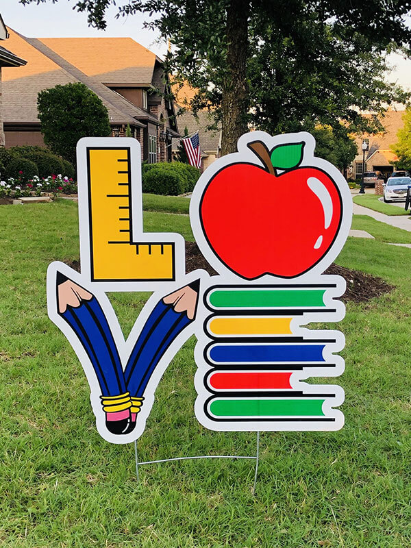 The word "Love" spelled with a square, apple, 2 pencils and a stack of books