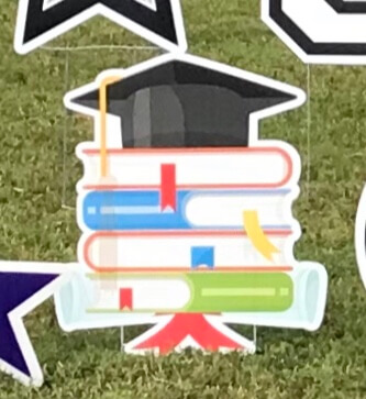 A stack of books with a mortar board on top